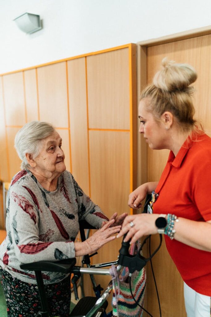 caregiver-talking-to-a-senior-woman-in-a-corridor-18429415 Caregiver Talking to a Senior Woman in a Corridor
